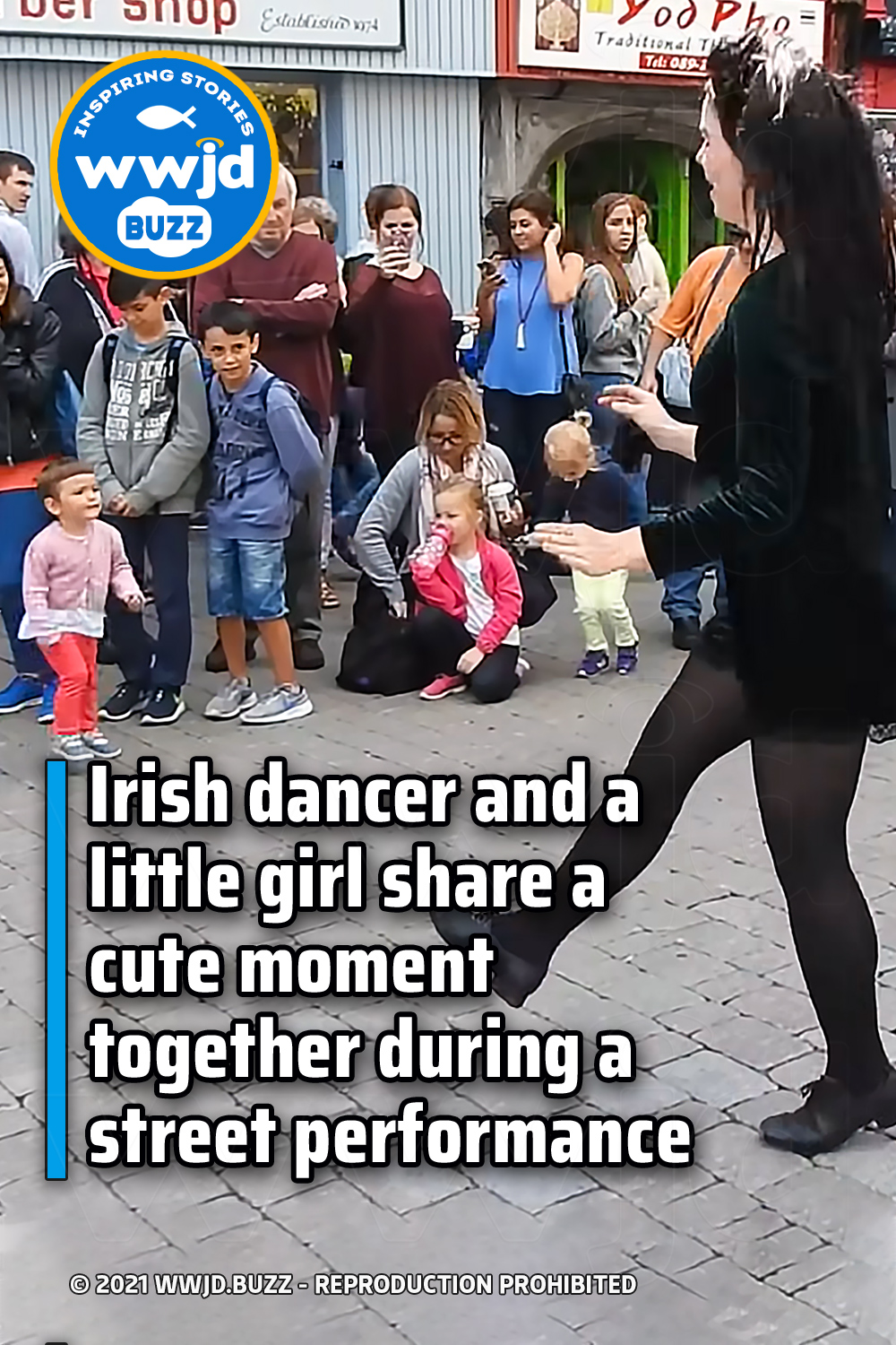 Irish dancer and a little girl share a cute moment together during a street performance